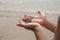 Little boy hand holding hermit crab in shell on the beach