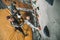 Little boy in a harness climbing a wall at gym with his father securing him from