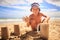 Little Boy in Hat Makes Sand Cake with Plastic Mug