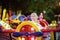 Little boy having fun on attraction in public park. Child riding on a merry go round at summer evening. Attraction, planes, cars,