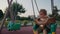 Little boy having fun on chain swing. The simple joys of childhood.