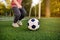 Little boy having fun playing a soccer/football game on summer day. Active outdoors game/sport for children