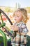 Little Boy Having Fun on A Tractor in a Rustic Ranch Setting at the Pumpkin Patch