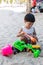 Little boy having lots of fun with his toys playing in the sand outdoors. Concentrated toddler playing with his toy. child plays w
