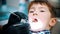 A little boy having a treatment in the modern dentistry - dentist in black gloves searching for the caries using