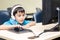 Little boy with headset using computer in classroom