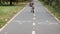 Little boy in a helmet on a bicycle rides on a bike path in the park