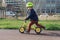 Little boy in a helmet riding Puky balance bike