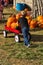 Little boy helping haul away pumpkins at the pumpkin patch