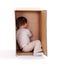 Little boy hiding in cardboard box
