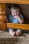 Little boy hiding under table