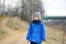 Little boy hiking in the forest on a early spring. Kid playing and having fun in spring or autumn day