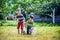 Little boy and his brother play in summer park. Children with colorful clothes jump in puddle and mud in the garden