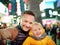 Little boy and his father taking selfie on Times Square in evening, downtown Manhattan