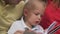 A little boy with his parents rites a book. Close-up