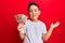 Little boy hispanic kid holding 10 colombian pesos banknotes celebrating achievement with happy smile and winner expression with