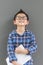 Little boy hold the book with hands having happiness against the gray wall