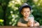 little boy holding disposable plastic glass of chocolate milkshake