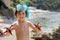 Little boy holding red five point starfishes in his hands on the