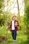 Little boy holding seedling of salad in pots and shovel on the domestic garden at summer sunny day. Gardening activity with little