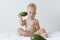 little boy holds avocado in his hands and smiles.