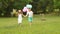 Little boy holds the girl by the hand and they run along the lawn together. Slow motion