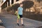 A little boy holds a GREEN penny in his hands while walking