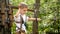 Little boy hooking safety rope before passing obstacles at rope adventure park. Kids sports, summer holiday, fun outdoors, scouts