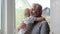 Little boy hugging his grandfather at home, senior positive man