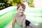 Little boy in inflatable pool outdoor