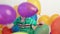 A little boy inflates a purple balloon