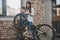 Little boy installing a new wheel onto his bicycle while his mother is standing