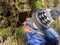 A little boy investigates a small hole in a sandstone wall