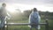 Little boy joining girl sitting on bench in sunlight. Back view of Caucasian friends admiring sunset on rainy summer day