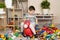 A little boy is jumping on an inflatable rubber donkey among the mess in the children's room. Bouncing toy for kids.