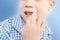 Little boy, kid nibbles and bites a nail on his hand, close-up, the concept of psychological disorder, stress, bad childhood