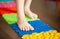 Little boy kid walking on a orthopedic massage mat. Treatment and prevention of flat feet in children