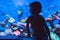 Little boy, kid watching the shoal of fish swimming in oceanarium, children enjoying underwater life in Aquarium