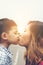 Little boy kissing his mom with the natural roadside.