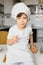 Little boy in kitchen.Cute boy wears a chef hat and apron