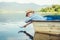 Little boy launch paper ship lying in old boat