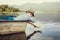 Little boy launch paper ship lying in old boat