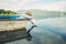 Little boy launch paper ship from old boat on the lake