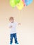 Little boy launches balloons.