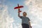 Little boy launches a toy plane into the air. Child launches a toy plane