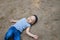 Little boy laying on ground pretending sleep or unconscious