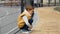 Little boy leaning on metal fence and sitting down. Child depression, problems with bullying, victim in school, emigration,