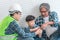 Little boy learning how to build brick wall from his construction Multi generation family