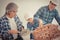 Little boy learning how to build brick wall from his construction Multi generation family