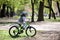 Little boy learns to ride a bike in the park. Cute boy in sunglasses rides a bike. Happy smiling child in helmet riding a cycling